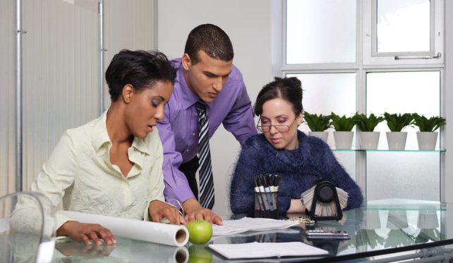 Three colleagues having a meeting with a laptop